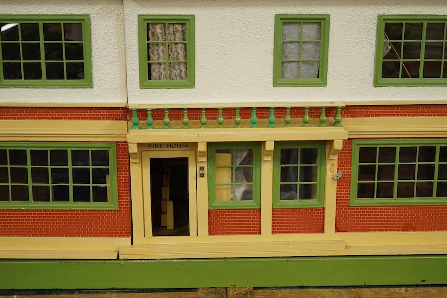A modern ‘Vine House’ dolls house with furniture and accessories; a large six room house with hall and stairwell, the front wall opening in two sections on hinges each side, with internal decoration and lighting, width 1